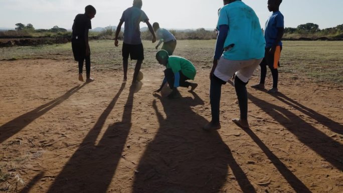贫困。缓慢的运动。贫穷的非洲黑人儿童在城镇贫民窟踢足球。