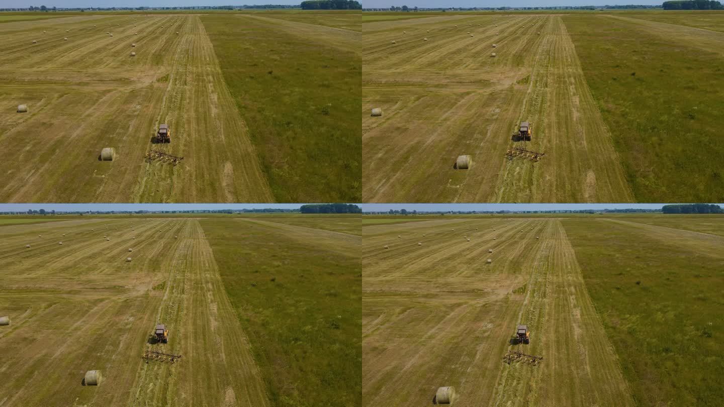 拖拉机与拖车tedder加速干草干燥移动收获的草在修剪的草地
