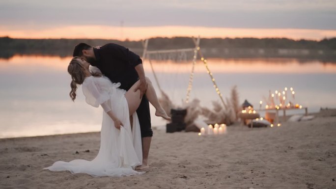 夕阳下，多民族情侣在沙滩上热烈拥抱亲吻，浪漫的新婚夫妇