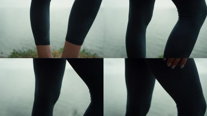 运动员的腿站在海滩山特写。坚强的女孩的脚踩在干草地上。