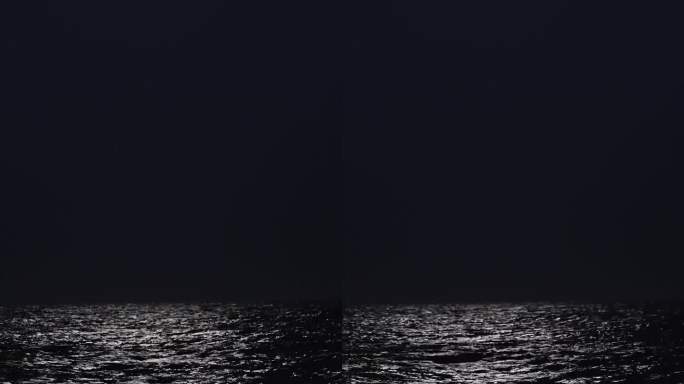 夜和月光上的海，波浪。一个年轻女子沿着海岸走的剪影，垂直，社交媒体