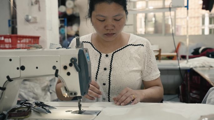 服装制作工厂生产工人工作缝纫机女工人夏天