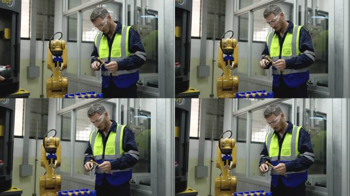 男工程师在工厂操作机器人的过程中使用工具检查零件