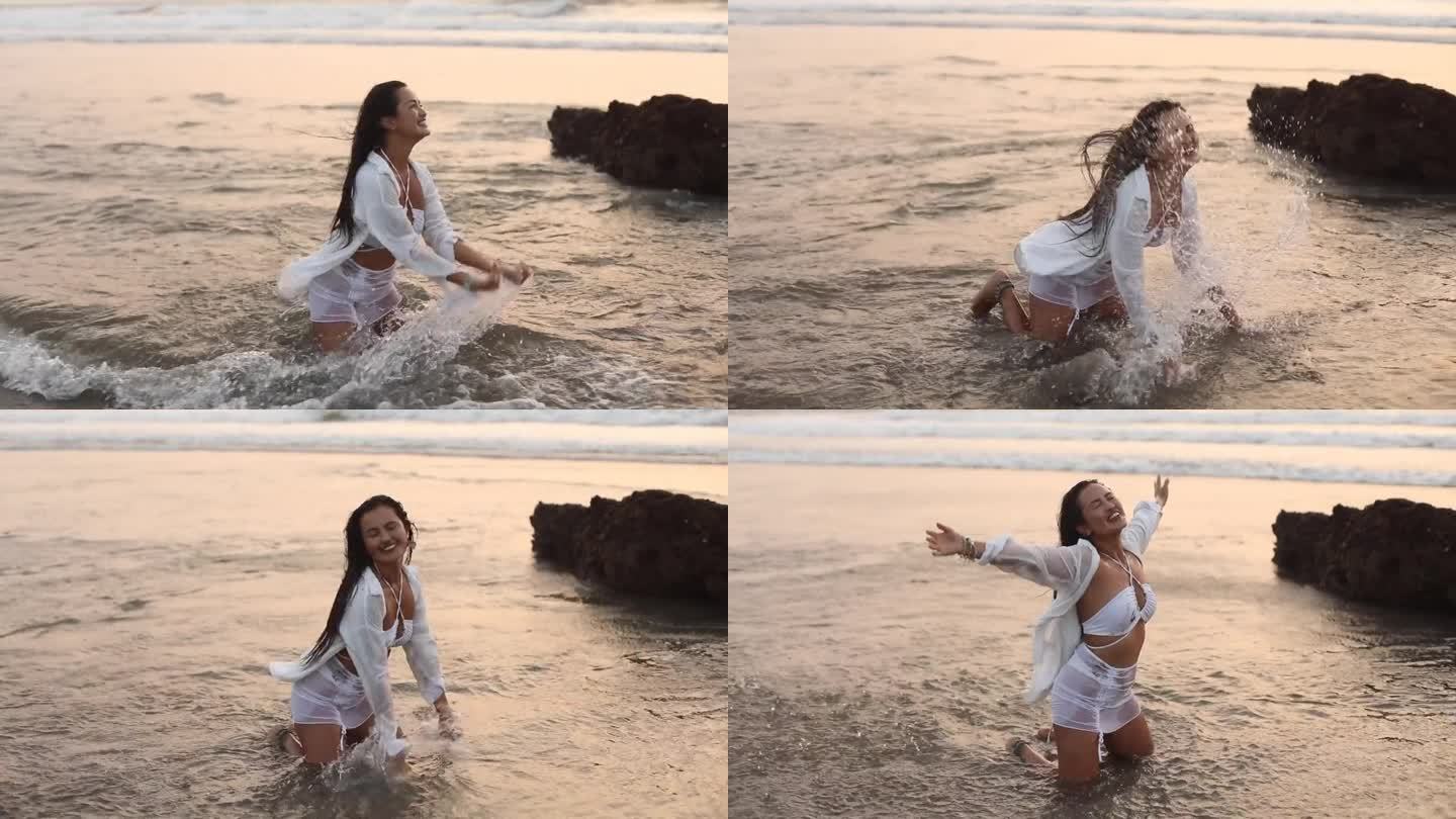 嬉笑，恶作剧的女人穿着比基尼，衬衫玩耍，溅起海水滴，波浪，跪在水里站在沙滩上