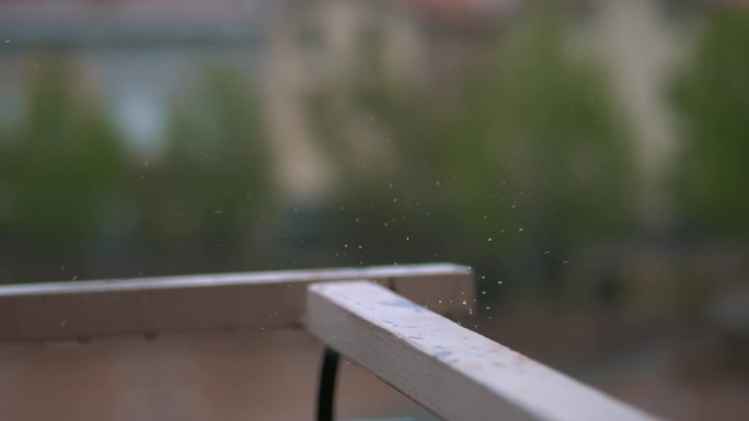 下雨了。光雨。雨滴落在阳台的栏杆上。降雨的近景。城镇广场背景雨滴。