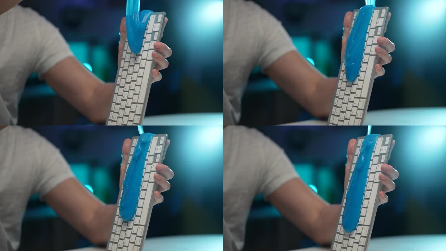细节裁剪镜头，蓝色粘稠的吸收性凝胶从手上滴下来，无法辨认的人在肮脏的白色无线PC键盘上。清理工作场所