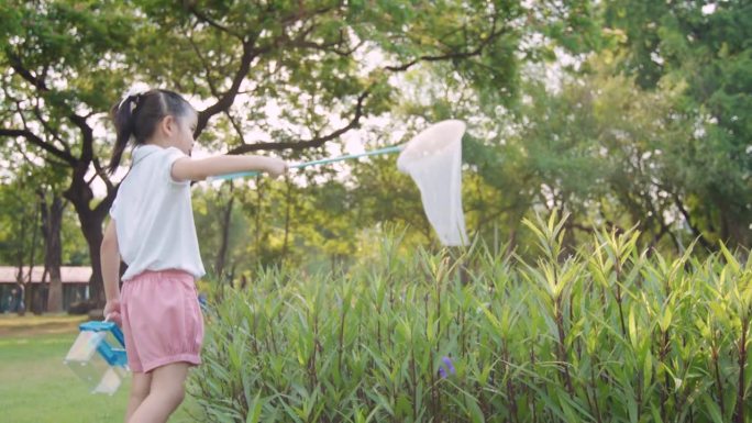 夏日里，小女孩一边走一边用网抓虫子