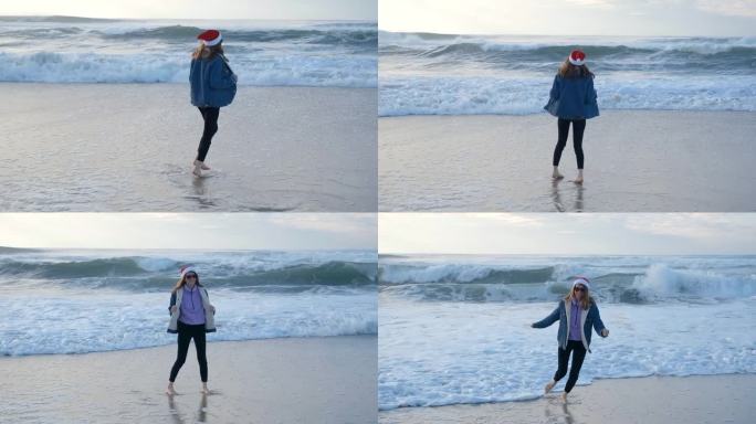 一个戴着红色圣诞老人帽的女孩或年轻女子在大西洋的海滩上玩耍，奔跑和转身。圣诞节或新年假期的概念。4K