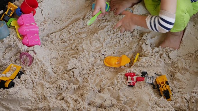 可爱的小男孩在家里用建筑玩具玩沙子，夏天的活动