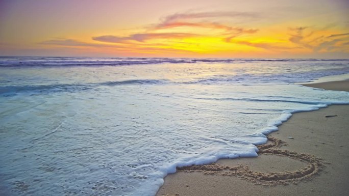 手绘数字2023文字在沙滩上，海洋日出或日落光在海滩岸边，金色的天空大海日落美丽的海滩背景