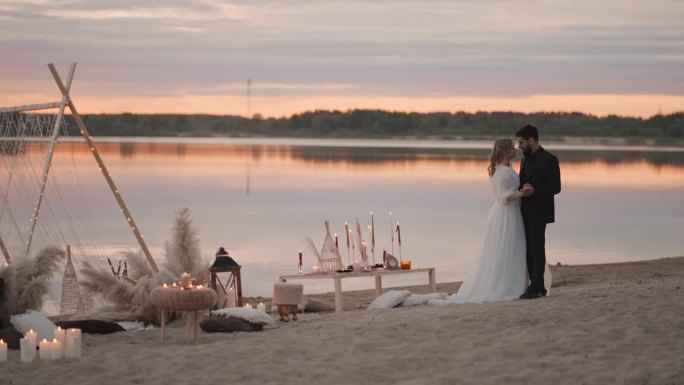 夕阳下，湖边浪漫的婚礼上，新婚夫妇温柔的拥抱和亲吻