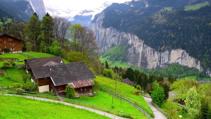 翁根村在山上，Staubbach瀑布在瑞士阿尔卑斯山的背景