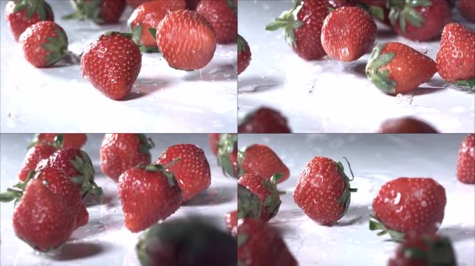 在白色背景上滚动的草莓。慢动作