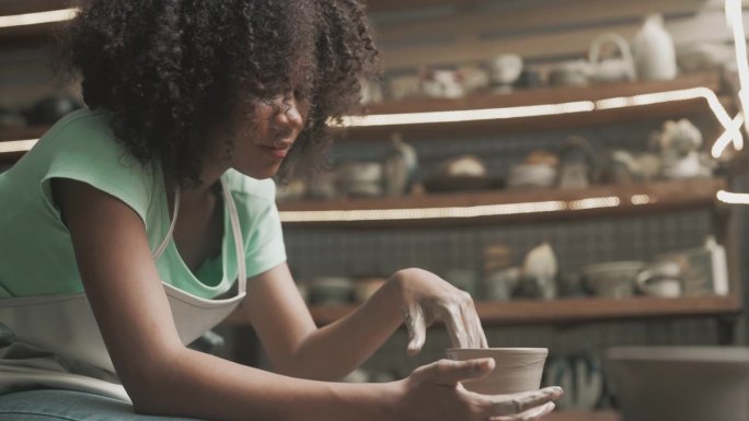 十几岁的女孩正在制作陶器作为休闲活动。