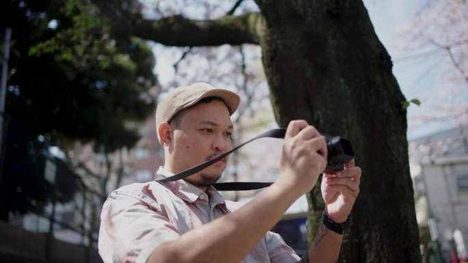 一名亚洲年轻人在东京游览，沉浸在周围的大自然中。,寻找快乐