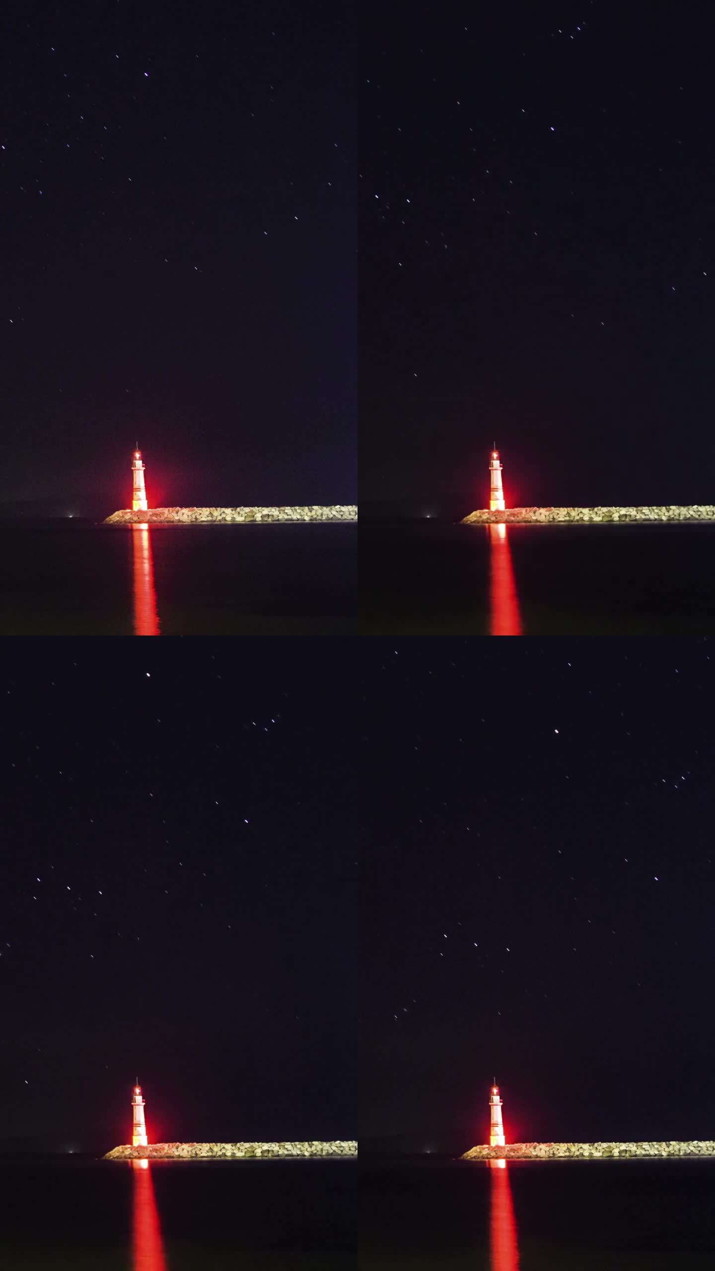 星空下的海滩。黑夜中指引方向的灯塔和伴随的星迹。社交媒体的垂直视频。