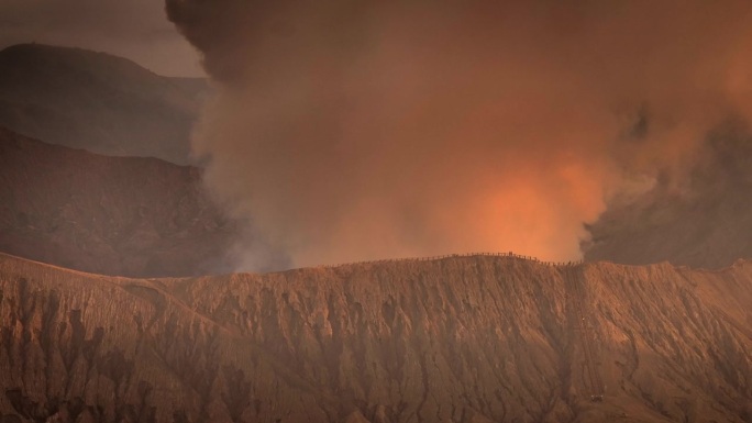 空中无人机拍摄的火山喷发日落场景，被云、雾和烟包围的Bromo火山与塞默鲁山、Batok和Widod