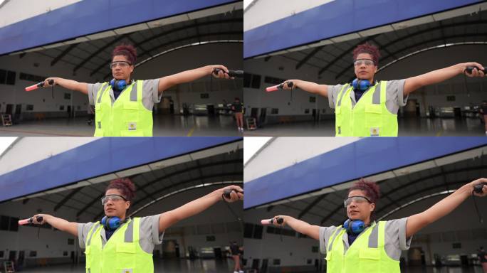 一名女子在机场用指挥棒给飞行员打信号