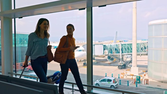 WS两名女性在机场检查智能手机