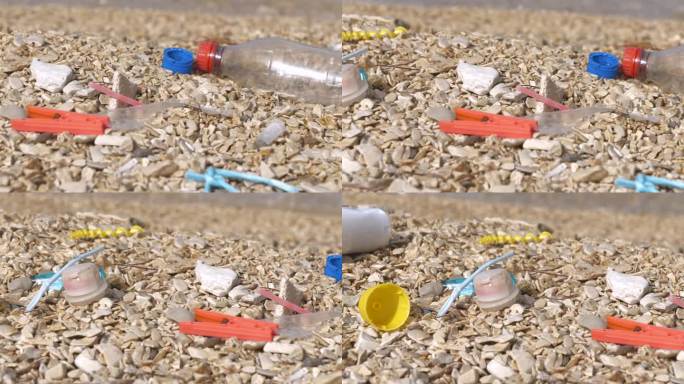 特写:被冲上岸的塑料垃圾残留在卵石海岸上，种类繁多，令人惊叹