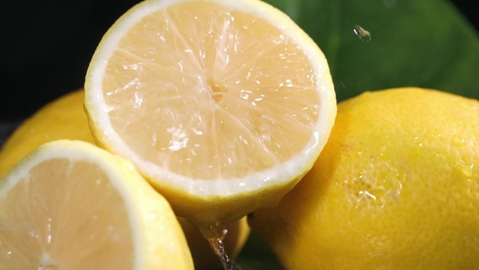 异国情调的柑橘类水果，多汁的柠檬在黑暗的背景上加水，特写