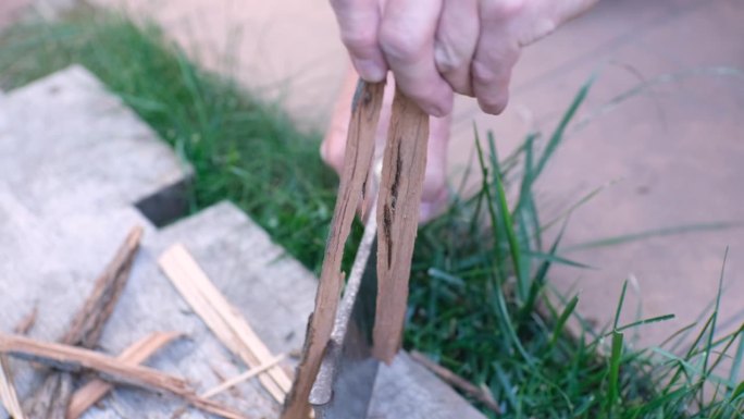 人类的手用斧刃为篝火制作木屑