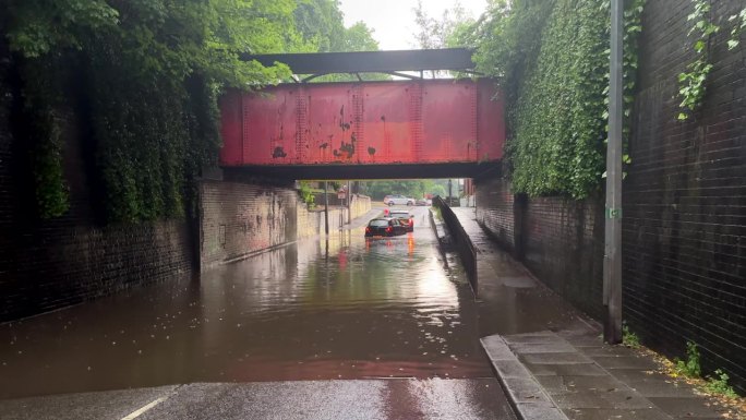 两辆汽车被困在桥下的洪水中
