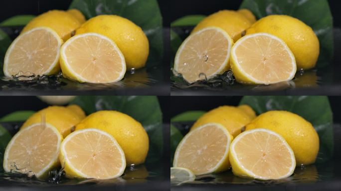 健康的维生素水果，成熟多汁的柠檬在切成黑色的背景上倒入水，特写