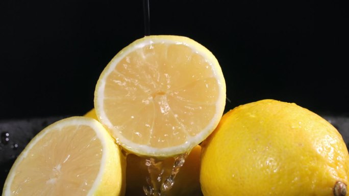 健康的柑橘类水果与水一起倒在黑暗的背景上，慢动作，特写