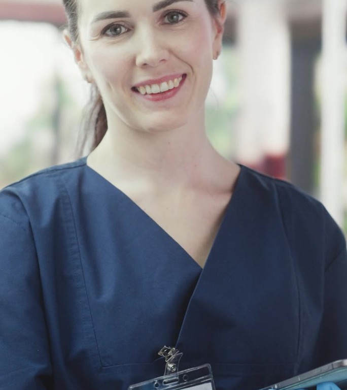 竖屏:献血中心女护士手持平板电脑检查血袋。职业白人女性面对镜头微笑。邀请捐赠者拯救生命。