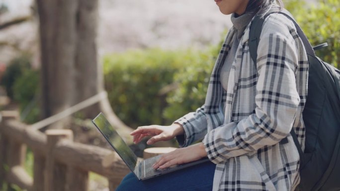 在自然公园用笔记本电脑工作的女性自由职业者