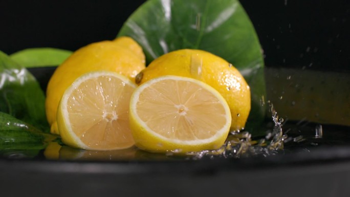 水果，成熟多汁的柠檬与水在黑暗的背景，特写