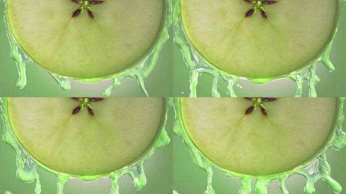 流动的青苹果汁从苹果切片，微距镜头在慢动作