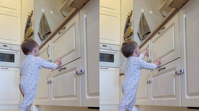 小婴儿打开了一个封闭的壁橱的门。一个好奇的孩子试图打开家具里的抽屉。10个月大的孩子