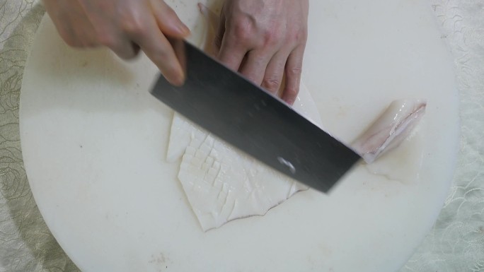 切鱿鱼白色案板刀工手部特写 海鲜处理做饭