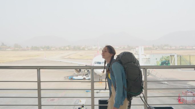 一名女子在机场行走，背景是飞机