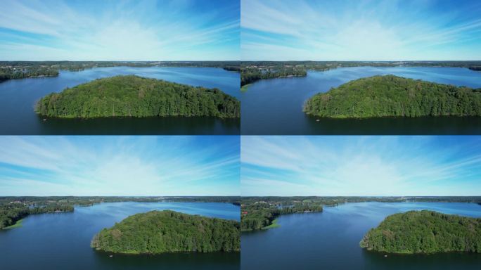 壮丽的鸟瞰平静的湖泊与岛屿在波兰。令人印象深刻的湖屋。天堂湖岸边的乡村房屋。水面上的宁静。绿树、森林