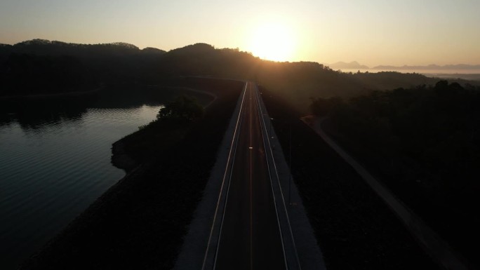 从空中拍摄的日出，对河上空旷的道路进行多重曝光