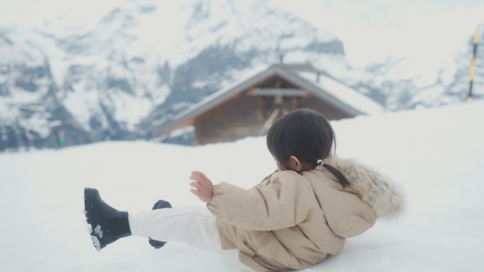 女婴第一次经历了雪。她穿着御寒的冬衣。