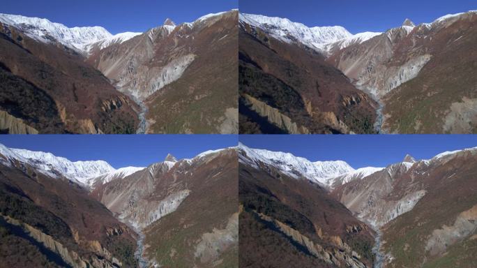 在阳光明媚的夏日，鸟瞰喜马拉雅山脉和山谷。雄伟壮丽的景观尼泊尔河流峡谷和山峰