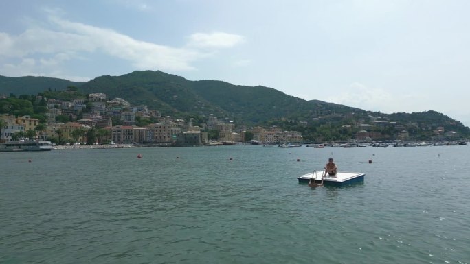 无人机拍摄的青少年在意大利利古里亚海上的浮动平台上玩耍的画面