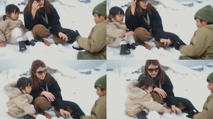 一群家庭坐在雪地上，一起玩雪人，在冬天的大自然中作为团队合作。