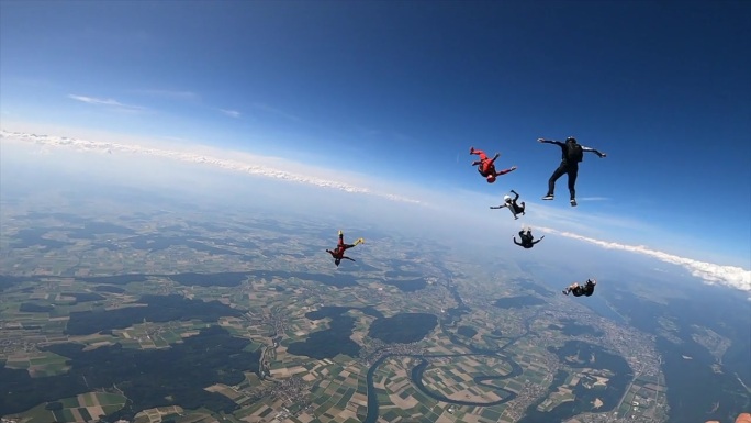 在阳光明媚的日子里，跳伞者在自由落体时表演杂技