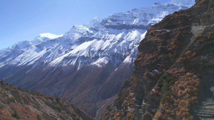 航拍照片男徒步者走在悬崖上的吊桥上蒂利科大本营徒步路线。喜马拉雅山脉安纳普尔纳环行。提里科大本营路线