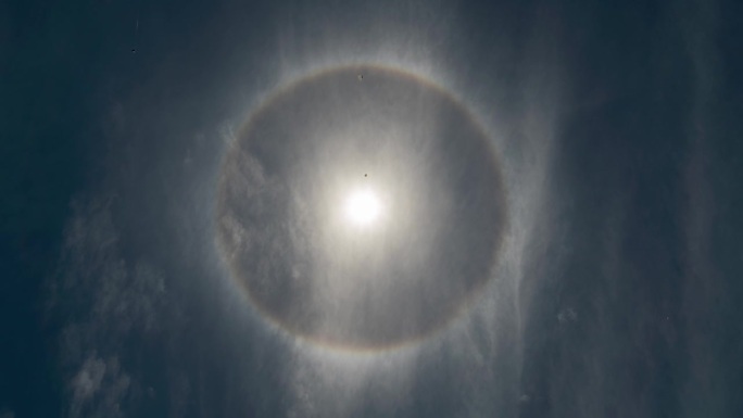 罕见的太阳周围的彩虹圆晕在蓝色天光天空时间推移光学现象