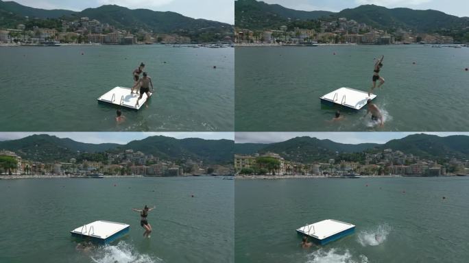 无人机拍摄的青少年在意大利利古里亚海上的浮动平台上玩耍的画面