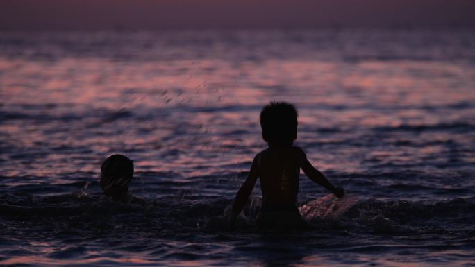 小孩傍晚海边游泳
