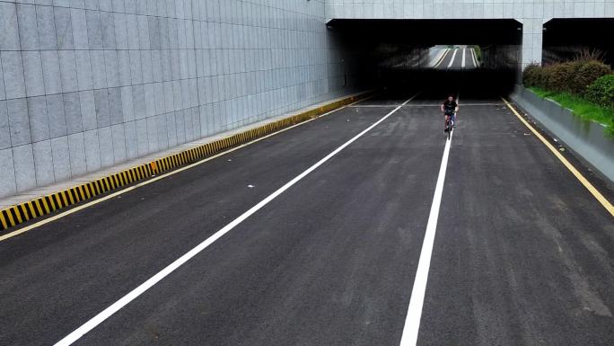一男子骑车经过隧道，沿直线行走