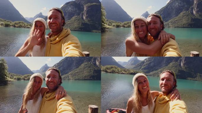 一对美丽的夫妇在群山环绕的湖上的码头上自拍