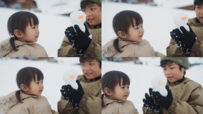 度假时，小男孩在雪地公园为他的小妹妹堆了一个可爱的雪人。